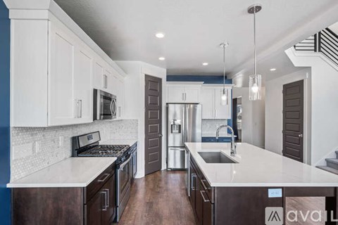 A modern kitchen with white cabinets and a central island.