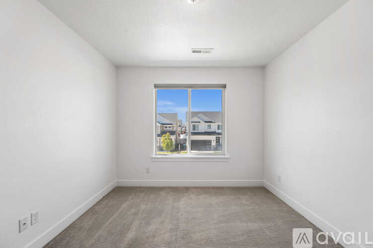 A room with a window showing a view of buildings outside.