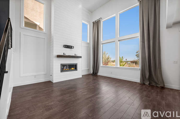 A spacious living room with a fireplace and large windows.