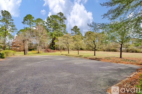 A paved area surrounded by trees and grass.
