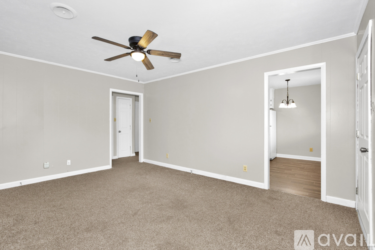A room with a ceiling fan and carpeted floor.