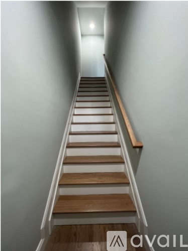 A staircase with wooden steps and a light at the end.