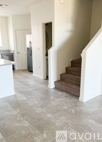 A kitchen with a refrigerator and stairs.