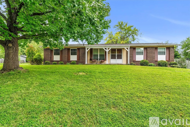 A house with a lawn and trees in front of it.