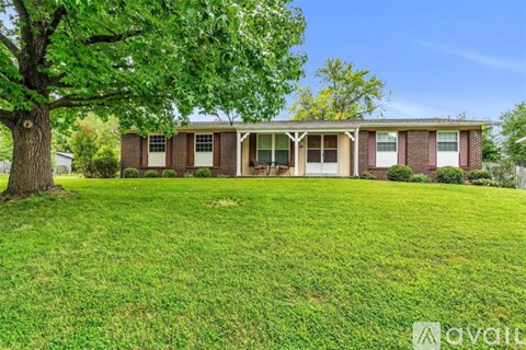 A house with a lawn and trees in front of it.