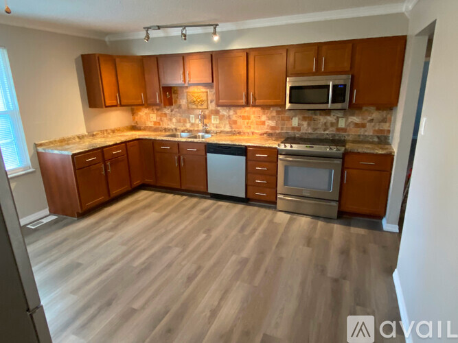 A kitchen with wooden cabinets and a stone backsplash.