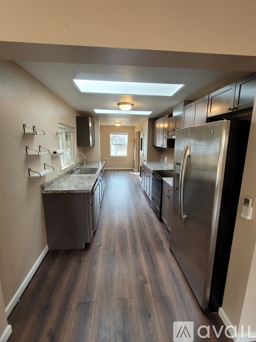 A kitchen with stainless steel appliances and wood flooring.