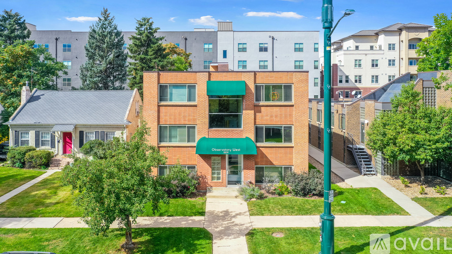 A building with a green awning and a sign that says "AVAILABLE" in front of it.