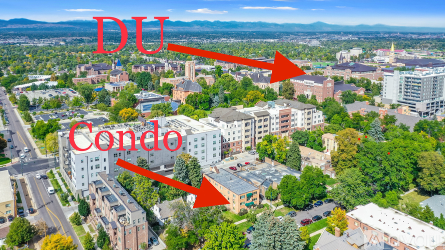 An aerial view of a city with a red arrow pointing to a condo building.