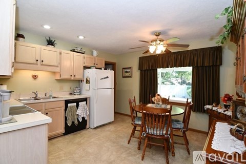 A kitchen with a table and chairs in front of a window.