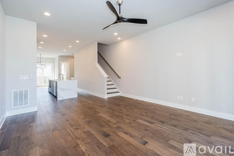 A spacious room with wooden flooring and a ceiling fan.