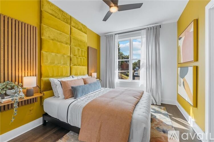 A bedroom with a bed, a window with curtains, and a ceiling fan.