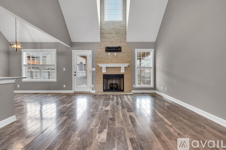A spacious living room with a fireplace and wood flooring.