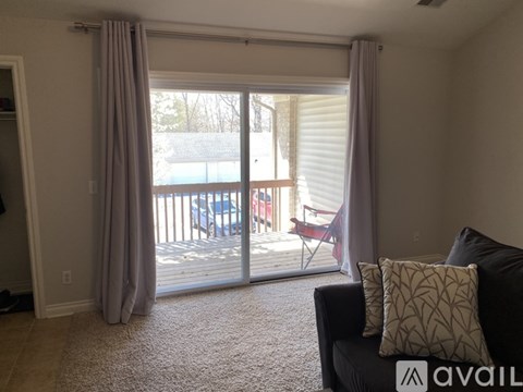 A living room with a couch and a sliding glass door leading to a balcony.