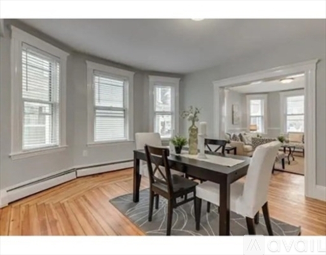 A dining room with a table and chairs.