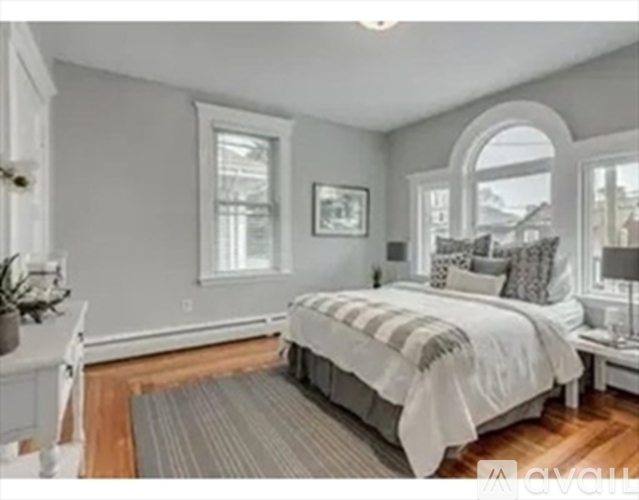 A bedroom with a large bed and a window.