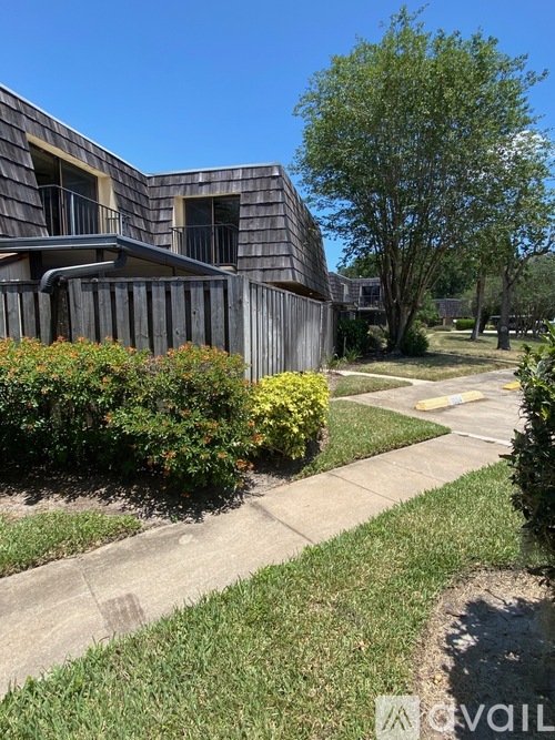 A modern house with a wooden exterior and a well-maintained lawn.