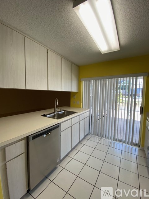 A kitchen with white cabinets and a dishwasher.
