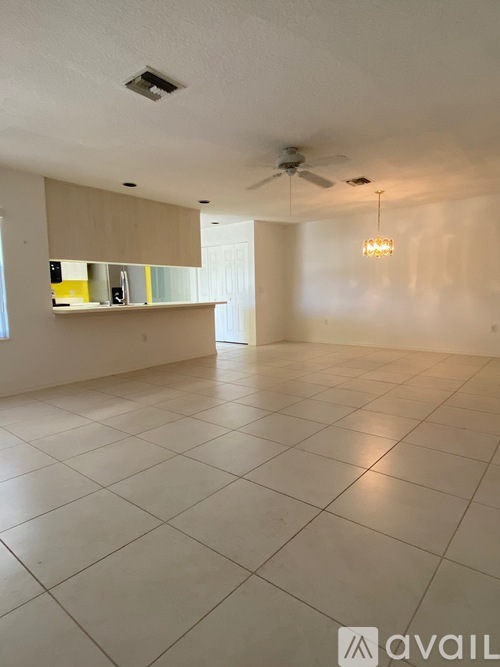 A spacious room with a ceiling fan and a light hanging from the ceiling.