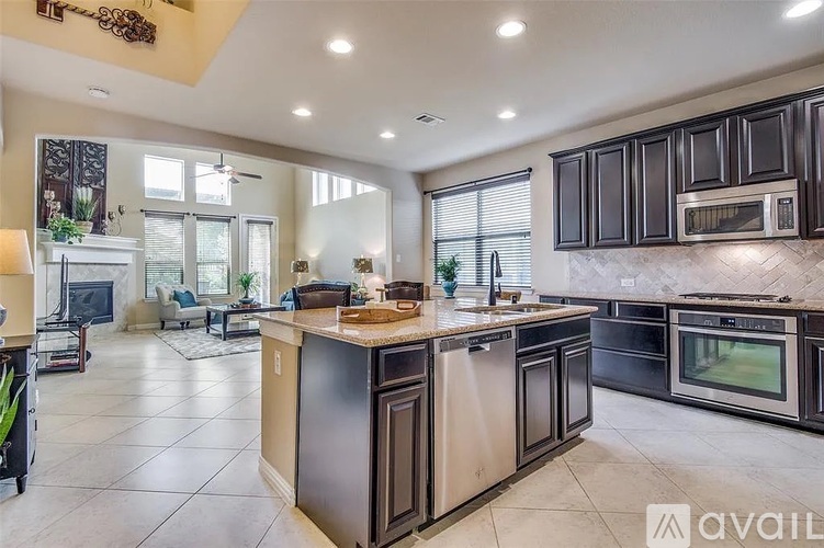 A modern kitchen with dark brown cabinets and stainless steel appliances.