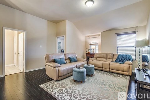 A living room with a tan couch and a rug.