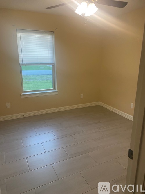 A room with a window and a ceiling fan.