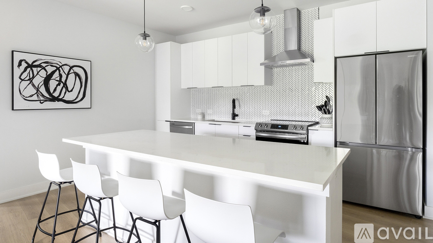 A modern kitchen with white chairs and a white table.