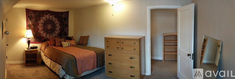 A bedroom with a bed, dresser, and mirror.
