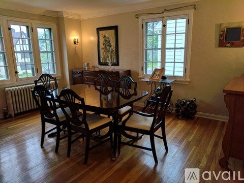 A dining room with a wooden table and chairs.