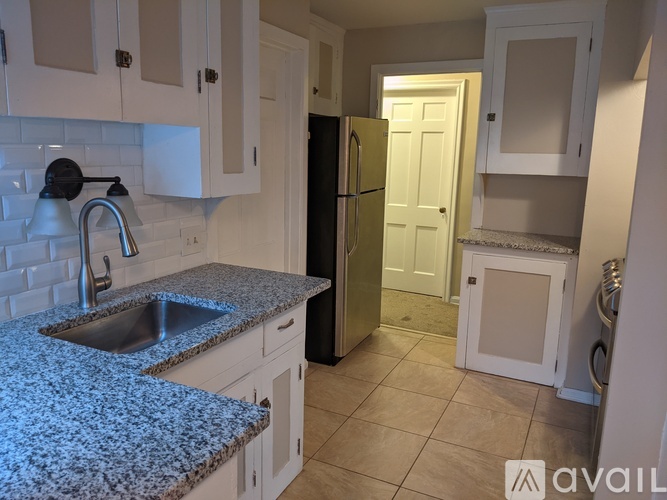 A kitchen with granite countertops and white cabinets.