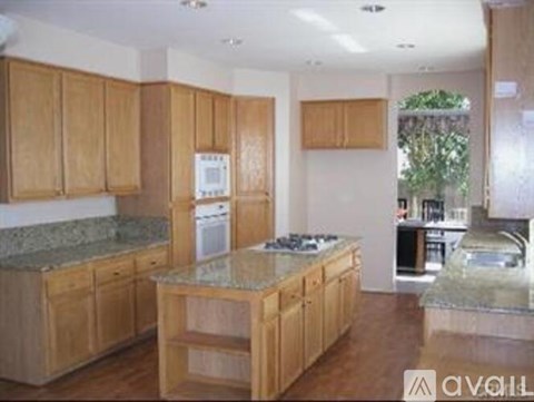 A kitchen with wooden cabinets and granite countertops.