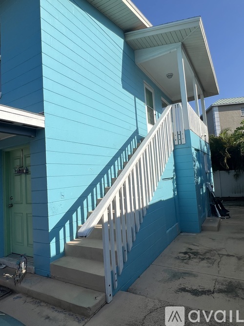 A blue house with a white porch and stairs.