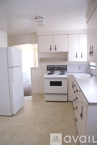 A kitchen with white appliances and cabinets.