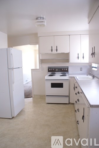 A kitchen with white appliances and cabinets.