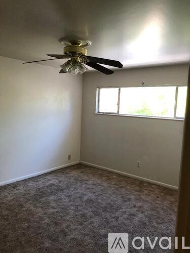 A room with a ceiling fan and a window.