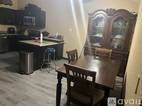 A kitchen with a dining table and chairs.