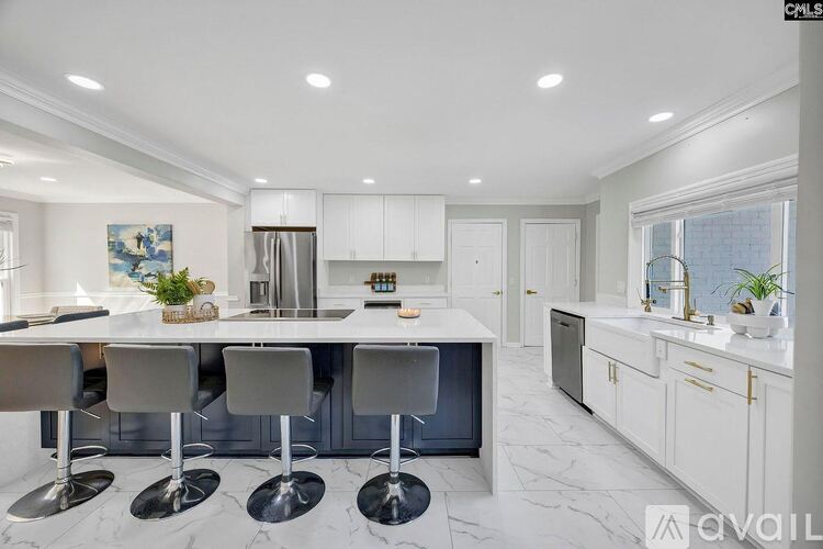 A modern kitchen with white cabinets and a central island.