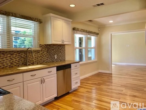 A kitchen with white cabinets and a granite countertop.