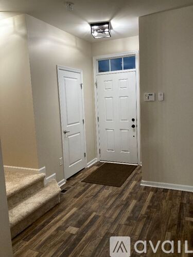 A hallway with two doors and a staircase.