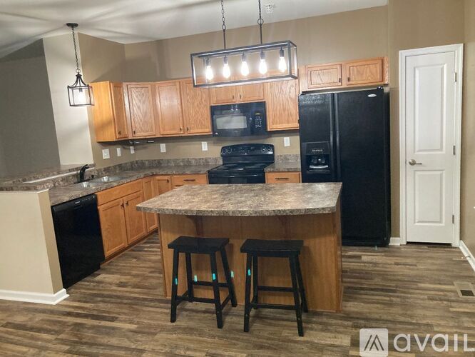 A kitchen with a granite countertop and black appliances.