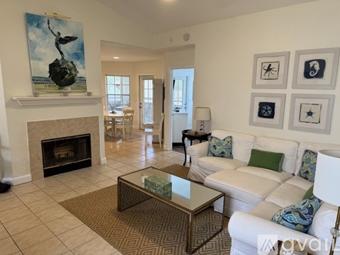 A living room with a fireplace and a painting of a person on a ball.