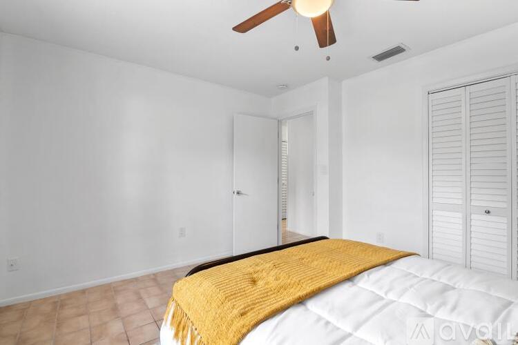 A bedroom with a bed and a ceiling fan.
