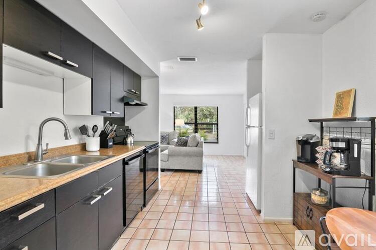 A kitchen with black cabinets and a tiled floor.