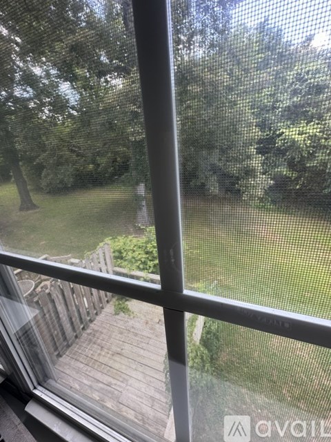 A view from a window looking out to a deck and trees.
