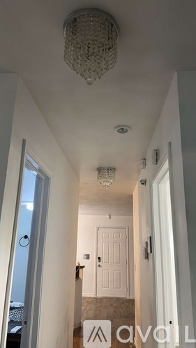 A hallway with a chandelier and a sign that says "available".