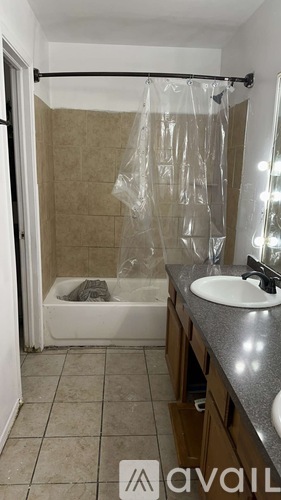 A bathroom with a shower curtain and a sink.
