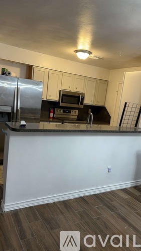 A kitchen with white cabinets and a black countertop.
