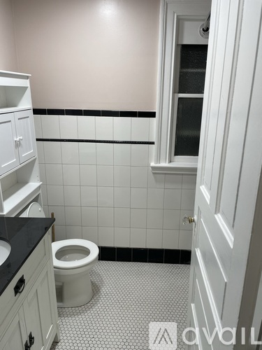 A white toilet in a bathroom with black and white tiles.