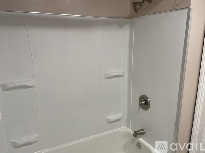 A white bathroom with a door and a handle.