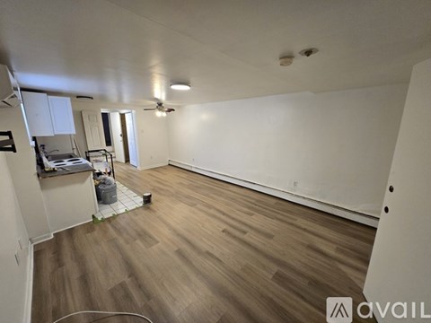 A room with wooden flooring and white walls is available for rent.